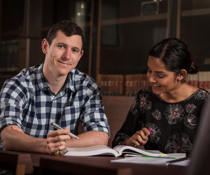 Two students looking at book